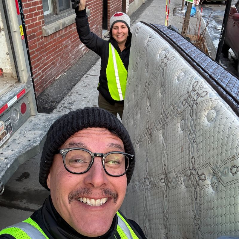 Équipe de Cycle Vert Recycle avec un matelas lors d’un ramassage en ville