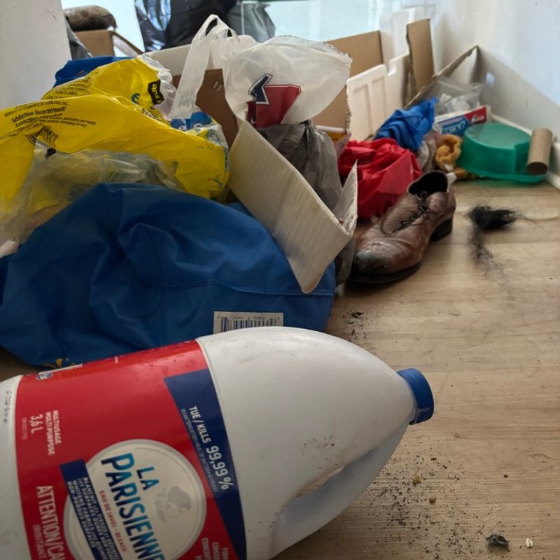 Sol encombré de déchets, objets divers et produits ménagers à évacuer
