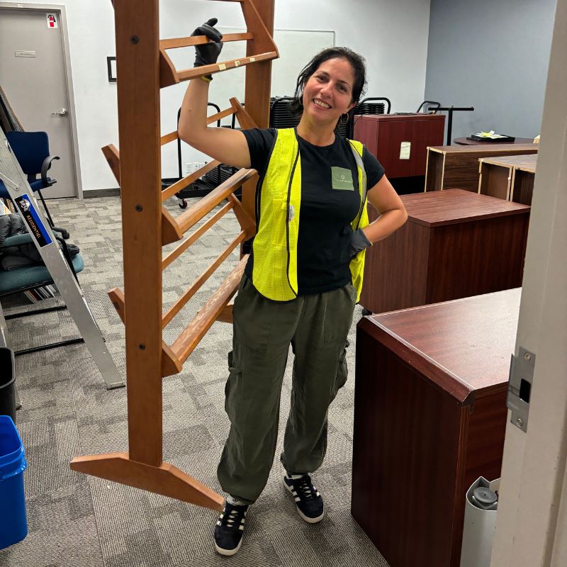 Employée de Cycle Vert Recycle transportant une étagère en bois dans un bureau